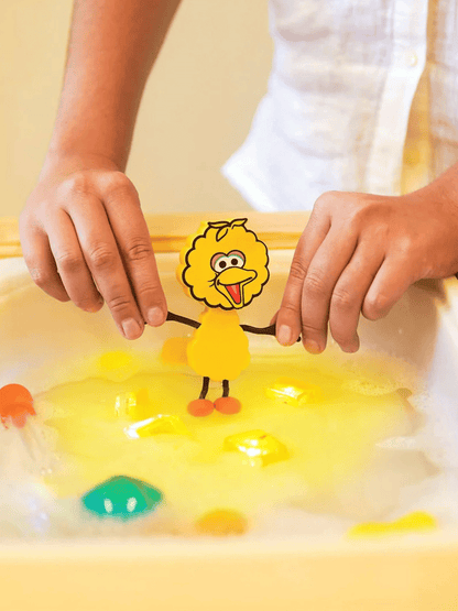 Cubi sensoriali che brillano nell'acqua con una figura di Sesame Street