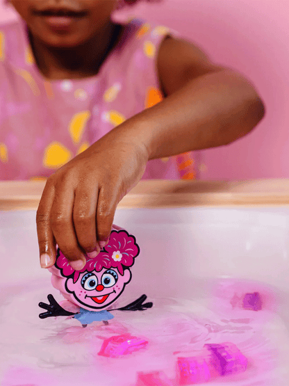 Sensory cubes glowing in water with a Sesame Street figure